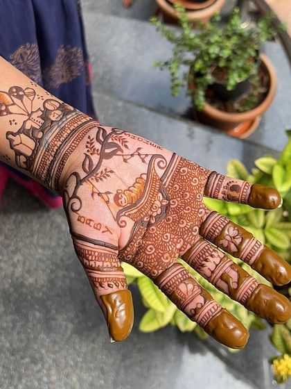 A close-up of the palm, showing a baby sleeping in a cradle under a tree. These narrative designs are what make baby shower mehendi so special.
