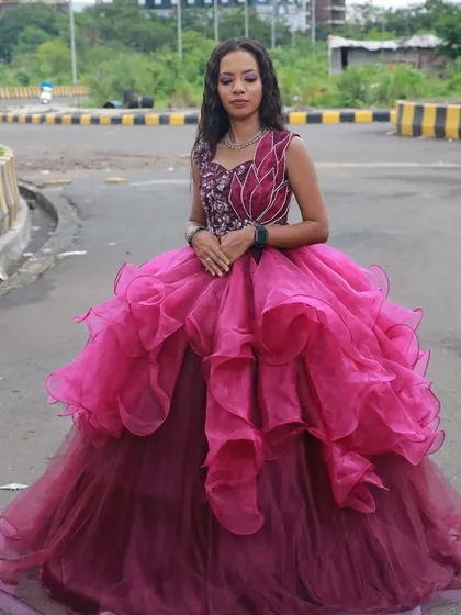 This ruffled magenta gown is paired with a dramatic makeup look, showing our students' ability to handle high-fashion concepts.