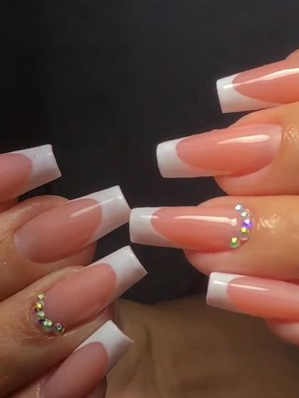 Long, square-tipped French nails with accent nails fully adorned with sparkling iridescent rhinestones for a glamorous effect.
