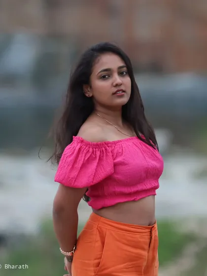 A half-body shot that highlights the off-the-shoulder design of the pink top.