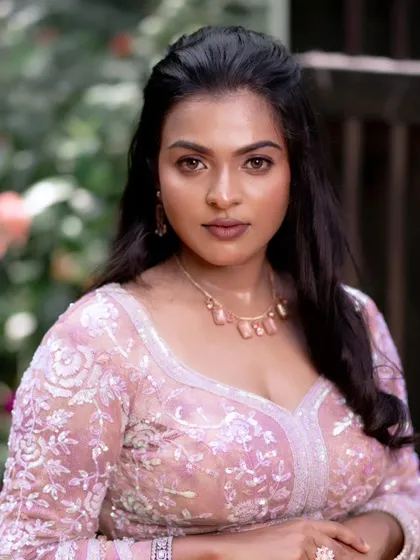 A model showcasing a glamorous look with a pink lehenga. The makeup is subtle, with a focus on glowing skin and natural beauty.