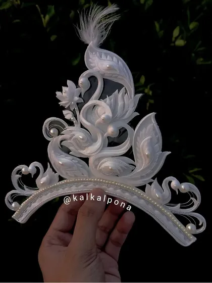 This exquisitely crafted mukut features elegant swan motifs and delicate pearl details, showcasing the incredible artistry that goes into each piece of traditional Bengali headwear.