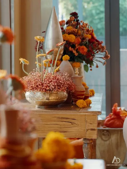 An artfully arranged corner with brass and terracotta vases, showcasing a mix of traditional and modern floral styling.