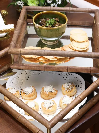 Our two-tiered mirror tray with a wooden bamboo-style frame offers a sophisticated way to serve appetizers. The mirrored surface adds a layer of glamour, reflecting the delicious treats it holds.