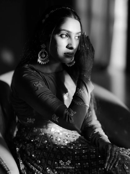 A dramatic black and white portrait of the bride, the play of light and shadow highlighting her beautiful features and intricate attire.
