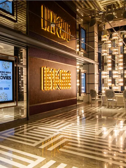 The entrance to the cinema screens at Maison INOX, where Art Deco grandeur continues. Geometric marble flooring with brass inlays and dramatic lighting create a sense of occasion, setting the stage for an extraordinary cinematic experience.