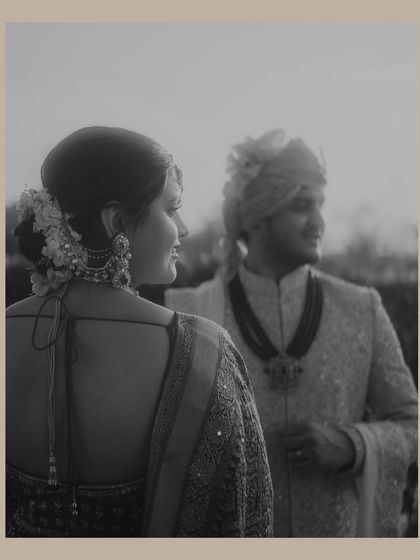 A soft and grainy black and white portrait of the couple. The focus on the bride's expression and the groom slightly out of focus creates a dreamy, nostalgic feel.