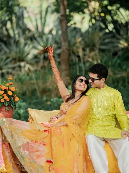 A relaxed and fun portrait of the couple lounging during their Haldi, sharing a happy and carefree moment.