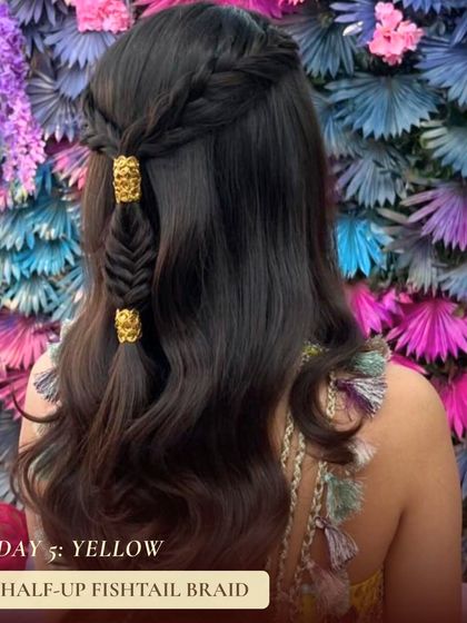This half up fishtail braid is a beautiful style for day five's yellow theme. Adorned with gold cuffs, this look is both bohemian and glamorous, perfect for a day of celebration.