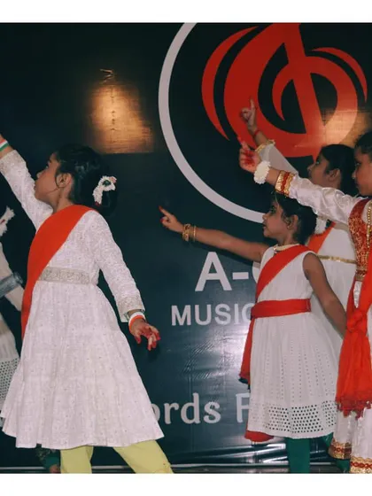 Students pointing upwards in a coordinated move during a group performance, symbolizing aspiration and unity.