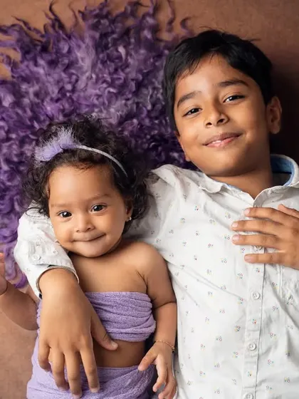 A protective and loving big brother wraps his arm around his baby sister. Capturing the beginning of a lifelong friendship is truly special.
