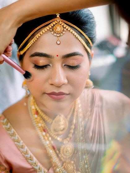 A behind the scenes glimpse of a South Indian bride getting her final touches. The focus is on creating a soft, blended look that feels light on the skin while providing a radiant finish.