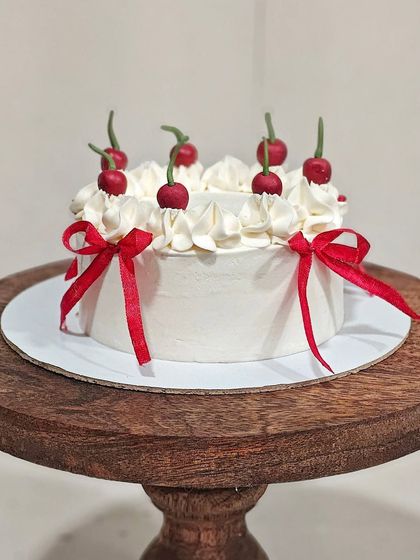 Another view of the cherry-themed cake, showing how the red ribbons are placed around the entire cake.