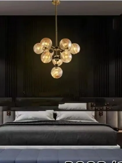 This gold globe chandelier adds a touch of luxury to a modern bedroom. The cluster of smoked glass globes provides a warm, intimate light that enhances the room's sophisticated design.