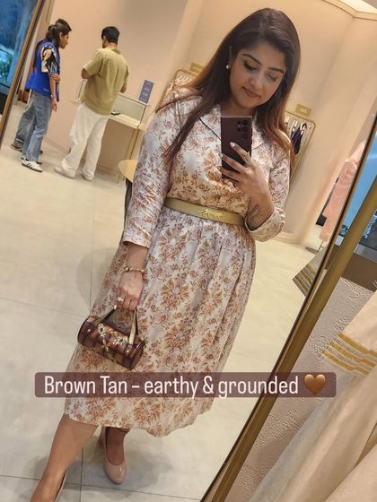 An earthy and grounded look with a brown tan bag that echoes the colors in the printed outfit.