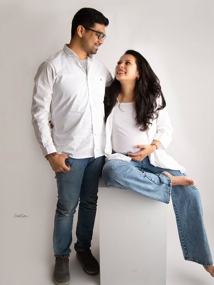 A casual and fun couple's maternity shoot. Dressed in jeans and simple tops, their relaxed interaction and happy smiles say it all.