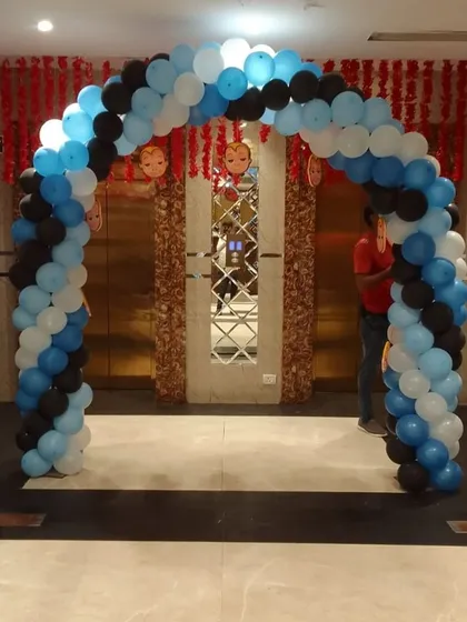 A blue, black, and white balloon arch serving as the entrance to a Boss Baby-themed party.