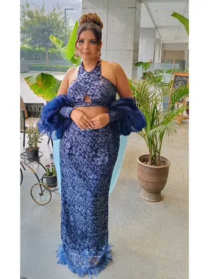 A full-length shot of a client looking stunning in a modern blue two-piece outfit. Her hair and makeup were done by our team to create a cohesive and glamorous party look.