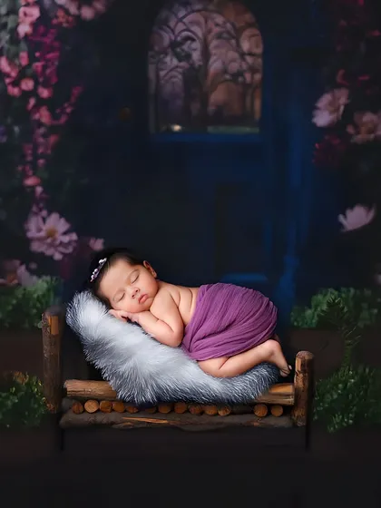A fairytale-like scene with a baby sleeping on a rustic wooden bed in an enchanted forest setting. This shows the creative backdrops I can use to bring a theme to life.
