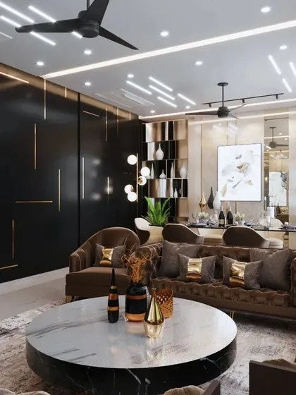This drawing room in Agra uses a rich, dark color palette to create a sense of intimacy and luxury. A large marble coffee table grounds the space, while plush, brown velvet sofas and gold accents provide warmth and opulence.
