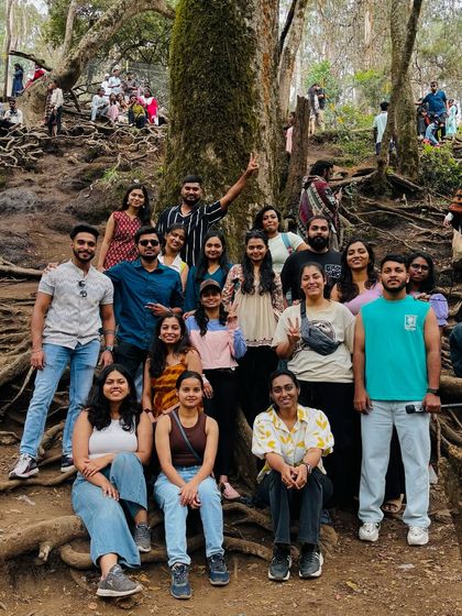 Our group gathered around the unique, exposed roots of a tree in Kodaikanal, a popular photo spot.