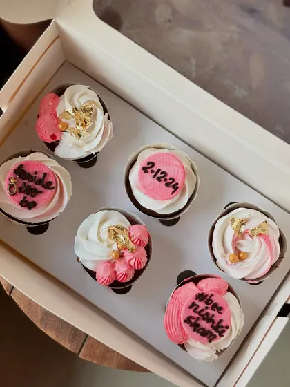 A pretty set of pink and white cupcakes for a bridal shower. I used gold leaf and custom toppers with the wedding date and a "bride to be" message.
