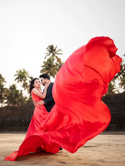 A breathtaking shot with a billowing red gown. This pre-wedding photo captures the drama and romance of a cinematic love story.