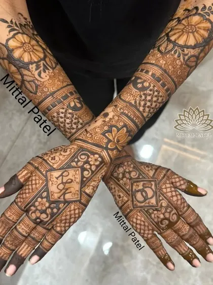 A full view of an engagement design, with the couple's initials and ring symbols set in a diamond-shaped frame, surrounded by floral and geometric patterns.