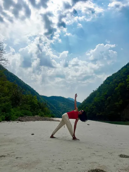 Performing Trikonasana, or triangle pose, on the sandy banks of the Ganga. Practicing in such a sacred and powerful place adds a completely different dimension to your yoga journey.