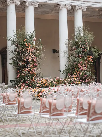 The ceremony seating arrangement at Hampton Court Palace, with custom cushions on the chairs. Every detail is considered to ensure a cohesive and elegant look.