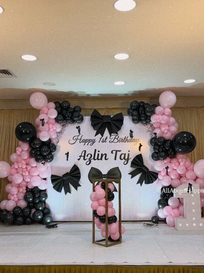 The full view of our bow-themed stage setup, featuring a personalized backdrop for Azlin Taj's first birthday, complete with a light-up number '1'.