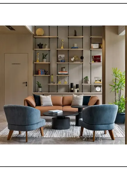 Office lounge with a leather sofa and industrial-style shelving.