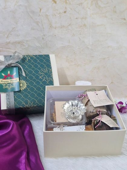 A classic corporate gift box containing a silver diya and our gourmet treats. It's an ideal choice for festive corporate gifting during Diwali.