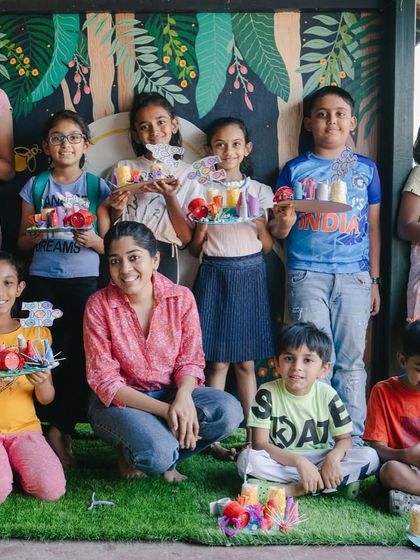 This is what a successful art camp looks like! A group of happy kids, a proud instructor, and a table full of amazing, colorful sculptures they all made themselves.