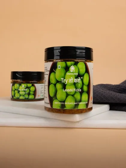 A styled shot of Lasoda Pickle jars on a marble board, showcasing the product in a simple, elegant setting.
