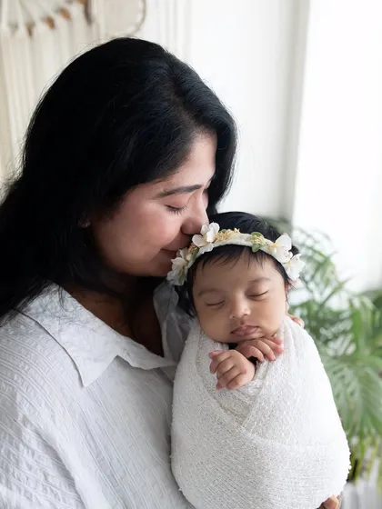 A mother's gentle kiss on her newborn's head. This close-up shot is full of emotion and tenderness, captured with soft, natural light.