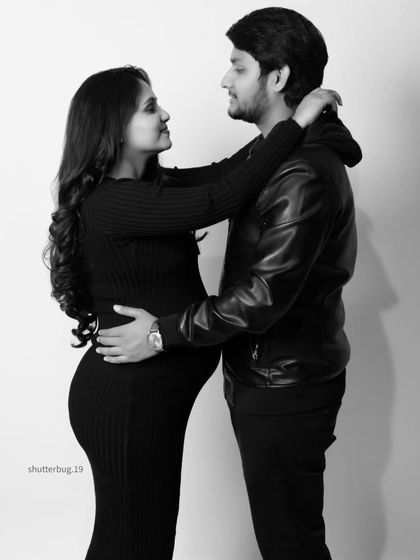 A modern black and white portrait of an expecting couple. Their coordinated casual outfits and loving gaze create a stylish and intimate photograph that feels authentic and timeless.