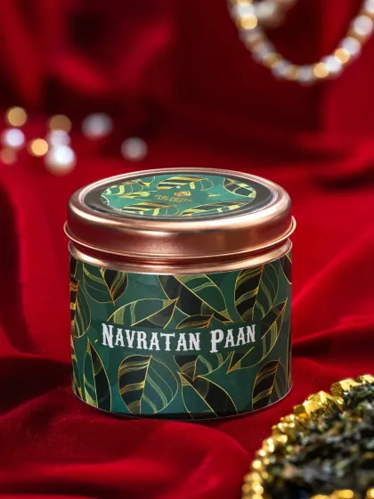 A premium tin of Navratan Paan, shot against a rich red velvet background to create a luxurious and festive feel.