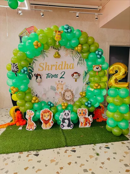 The complete jungle theme photo booth for a second birthday, with a faux grass floor.