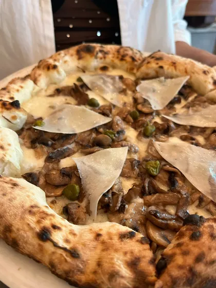 A close-up of the Funghi e Capperi pizza, showing the shaved parmesan and capers.
