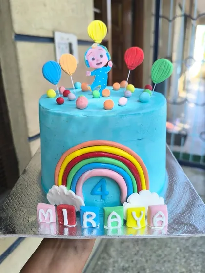 You can't escape the melon. This bright and cheerful Cocomelon cake is perfect for a toddler's birthday, featuring JJ, a big rainbow, and colorful letter blocks spelling out the birthday girl's name.