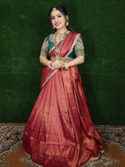 A full-length shot showing the complete red and green Langa Voni outfit. The rental includes the gold waist belt (kamarbandh) to complete the look.