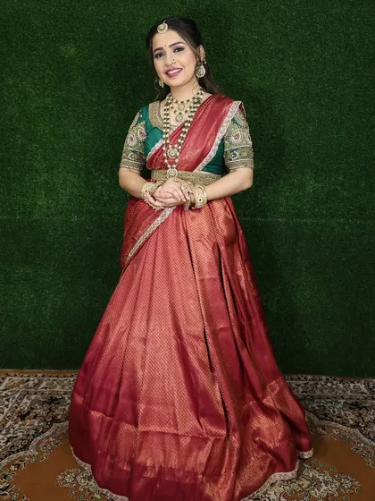 A full-length shot showing the complete red and green Langa Voni outfit. The rental includes the gold waist belt (kamarbandh) to complete the look.