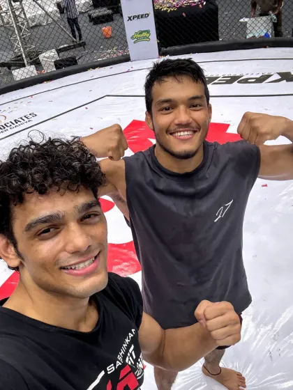 Two of our champion fighters celebrating a victory inside the VFC octagon. The smiles show the joy that comes after months of hard work.