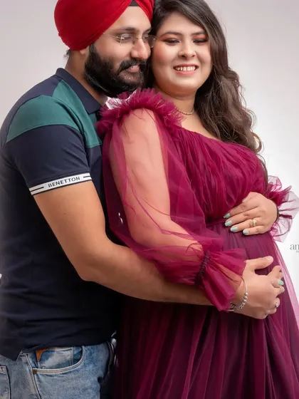 A candid and sweet moment captured in the studio. The partner's embrace from behind is a classic pose that feels warm, protective, and full of love.