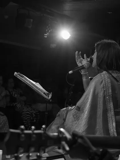 A view from behind the guitarist, looking out at the artist and the engaged audience. This perspective shows the complete connection in the room during the "Phir Le Aayi Dil" concert.