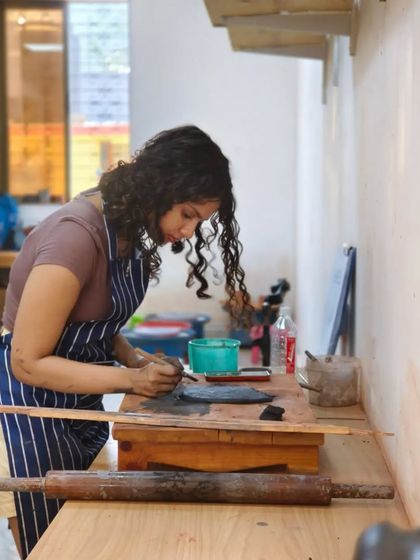 An artist at her workstation, deeply engrossed in her project. Our studio provides a dedicated space for students to immerse themselves in their art and bring their ideas to life.