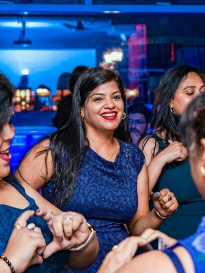 More friends dancing and enjoying the vibrant atmosphere. The blue lighting sets a cool, energetic mood.