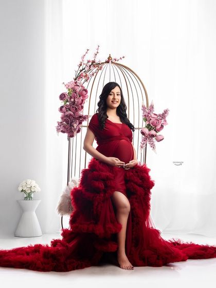 A full shot of the birdcage theme, showing the magnificent spread of the red ruffled gown. This setup is perfect for clients wanting a unique and glamorous maternity portrait.