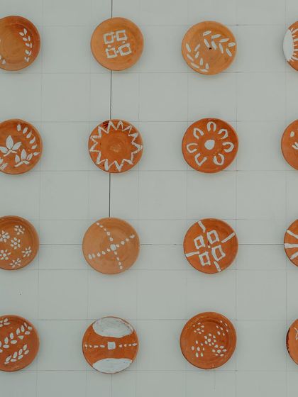 A close-up of the hand-painted pottery plates, each with a unique, traditional Rangoli design.